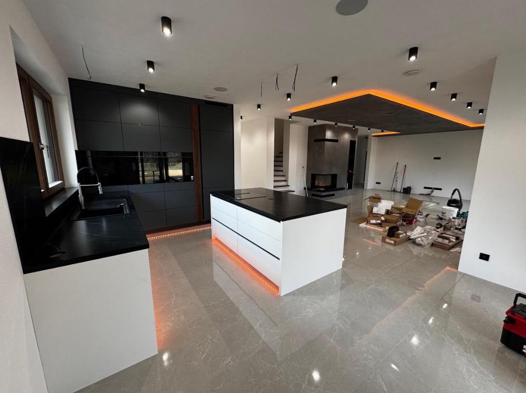 Spoločenská časť domu — kuchyňa, jedáleň a obývačka s krbom