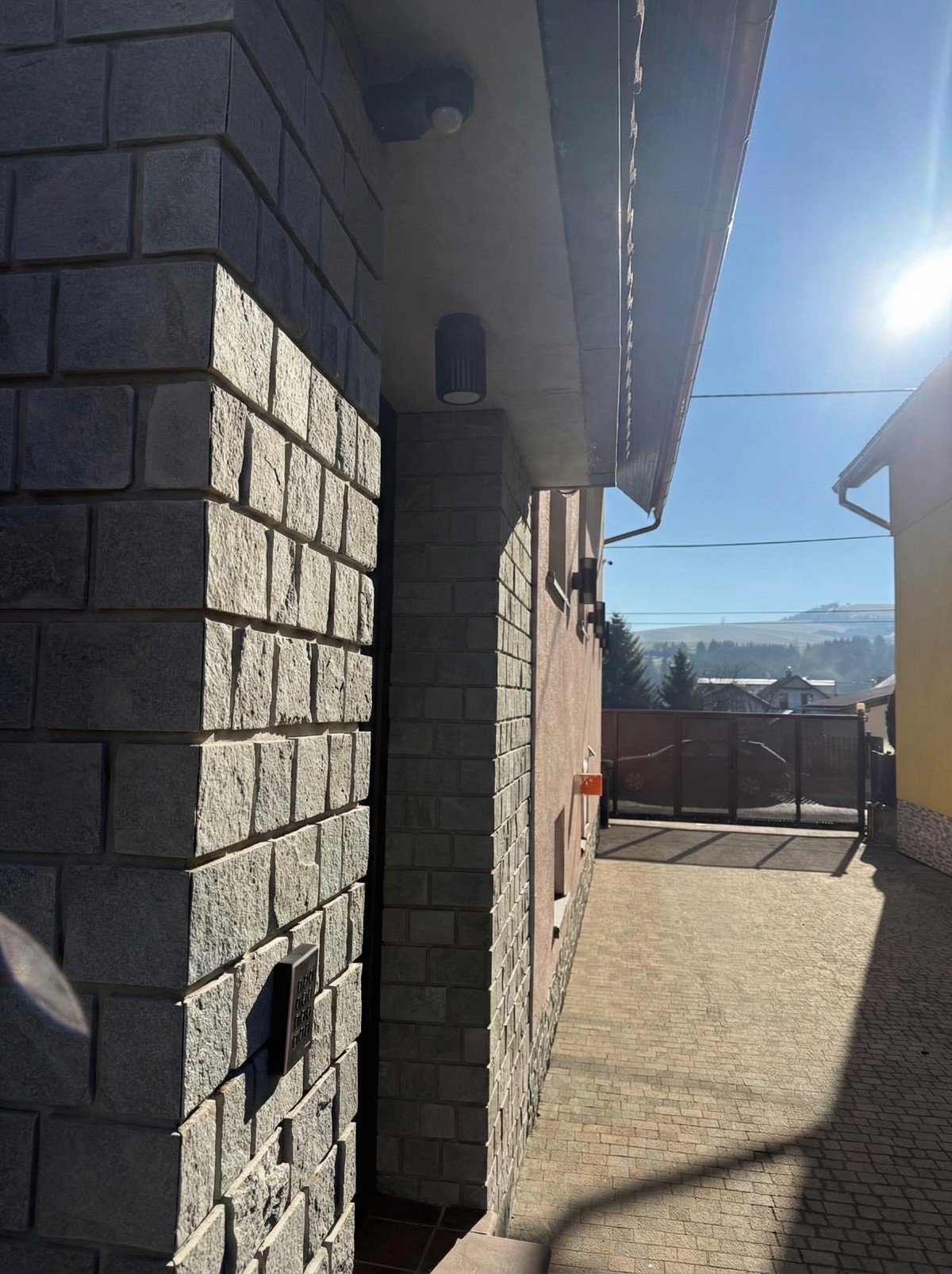 Vstup na terasu s kamenným obkladem, přístupovou klávesnicí a výhledem na hory